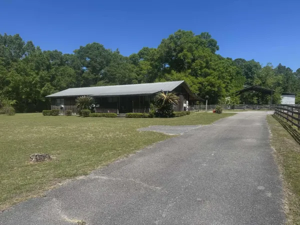 a view of a house with backyard and trees