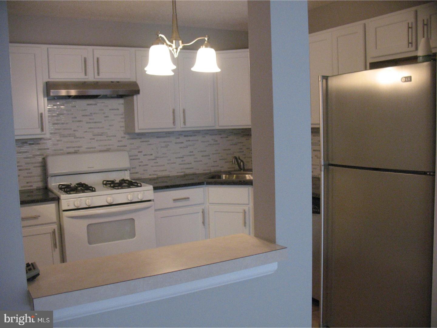 14 Versailles Court Hamilton, NJ 08619 - Photo 3 of 20 a kitchen with a refrigerator sink and cabinets