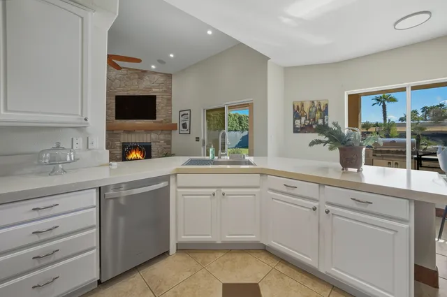 a kitchen with white cabinets and sink