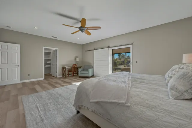 a spacious bedroom with a bed and ceiling fan