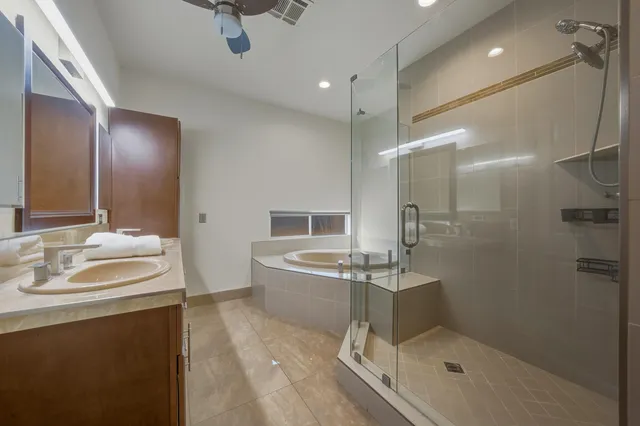 a bathroom with a sink a counter top space toilet and shower