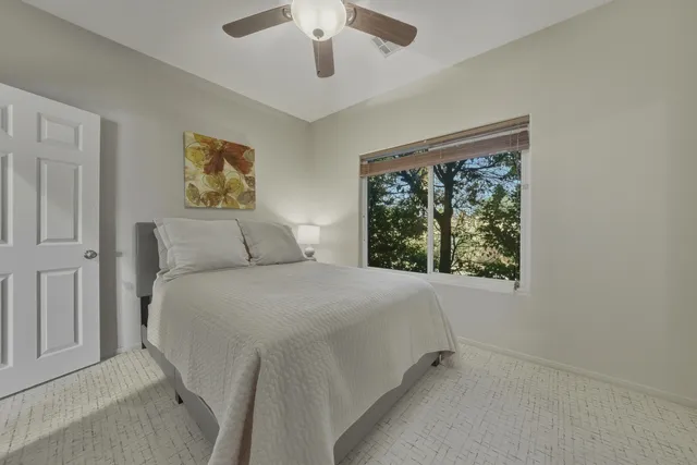 a bedroom with a bed and a painting on the wall