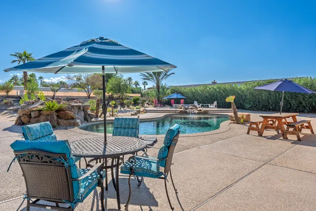 a view of a chairs and table in patio with a yard