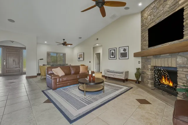 a living room with furniture a flat screen tv and a fireplace