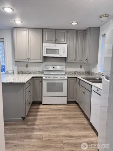 a kitchen with stainless steel appliances granite countertop a stove a sink dishwasher and a refrigerator