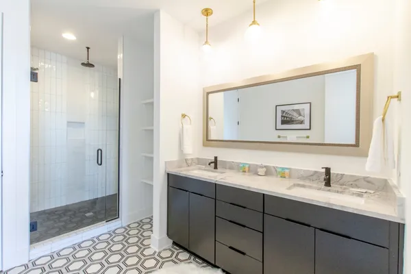 a bathroom with a double vanity sink mirror and shower