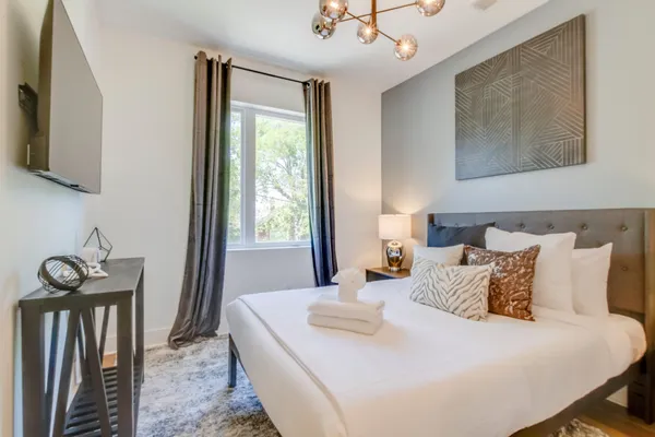 a bedroom with a bed and a flat tv screen on the dresser
