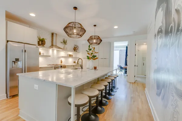 a large kitchen with stainless steel appliances a large center island attached withe living room