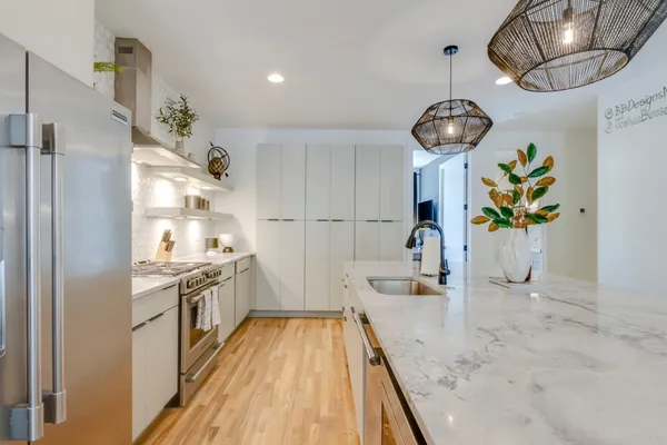 a kitchen with stainless steel appliances granite countertop cabinets a stove and a chandelier