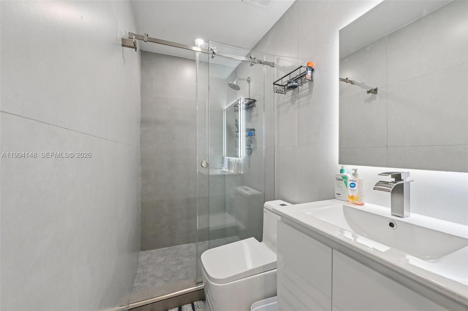 5152 Southwest 6th Street Miami, FL 33134 - Photo 13 of 43 a bathroom with a granite countertop sink toilet and shower