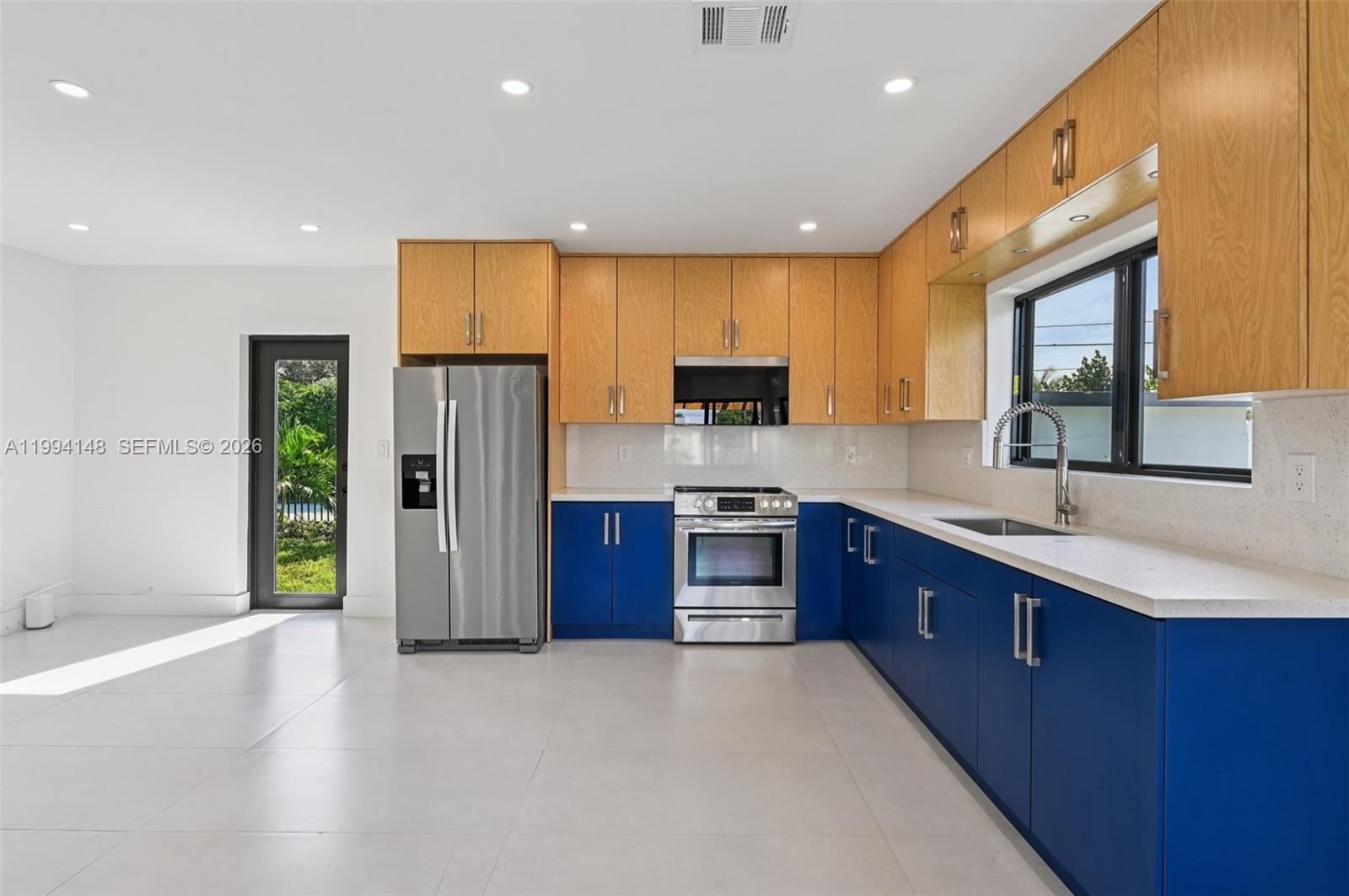 5152 Southwest 6th Street Miami, FL 33134 - Photo 38 of 43 a large kitchen with stainless steel appliances granite countertop a refrigerator a sink dishwasher a oven with large countertops