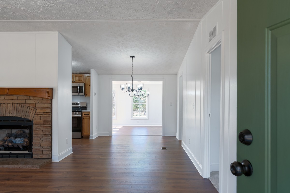 4214 Oregon Road Springfield, TN 37172 - Photo 7 of 37 an empty room with wooden floor a fireplace and windows