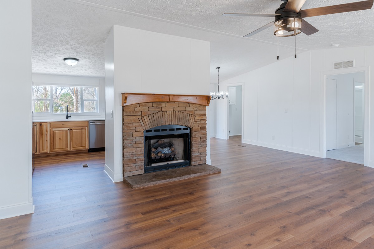 4214 Oregon Road Springfield, TN 37172 - Photo 9 of 37 an empty room with kitchen fireplace and wooden floor