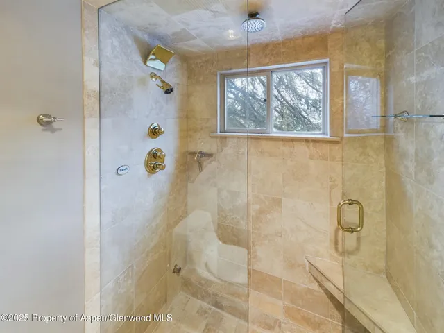 a bathroom with a window and glass door