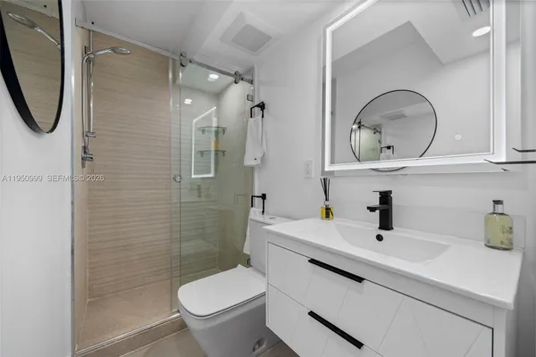 a bathroom with a sink a toilet and shower