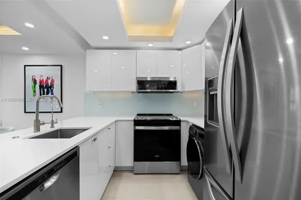 a kitchen with stainless steel appliances granite countertop a refrigerator and a sink