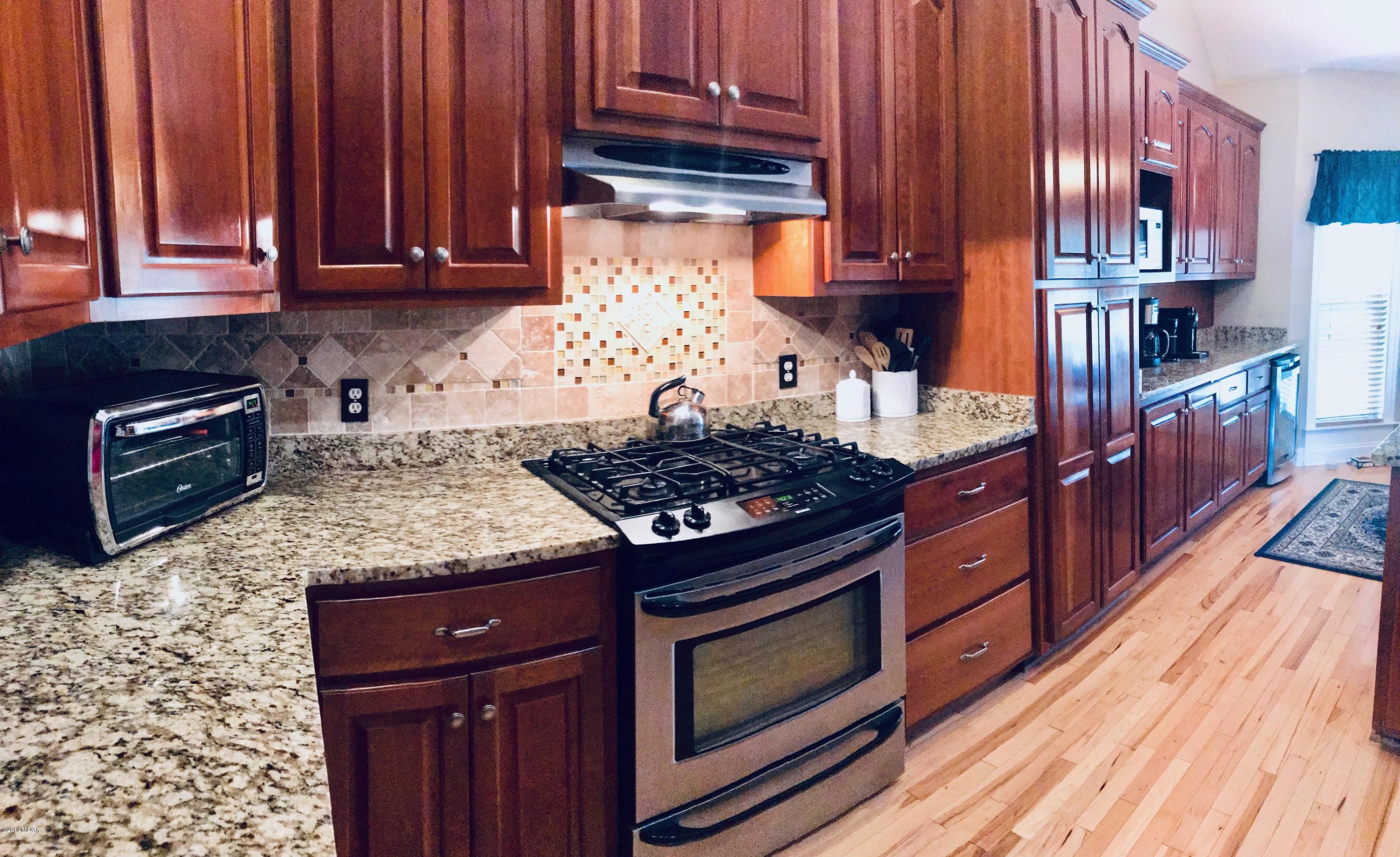 351 Eagle Ridge Road Macon, GA 31216 - Photo 4 of 33 a kitchen with granite countertop wooden cabinets and a stove top oven