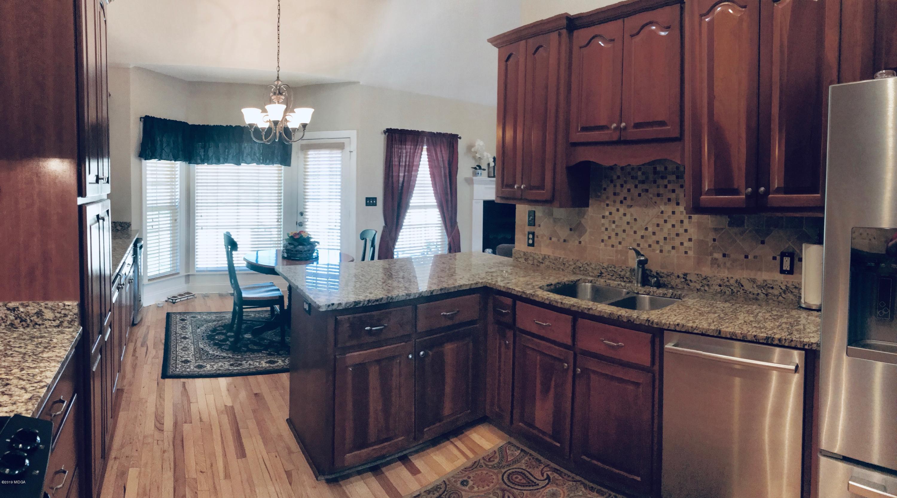 351 Eagle Ridge Road Macon, GA 31216 - Photo 5 of 33 a kitchen with granite countertop wooden cabinets a sink and dishwasher