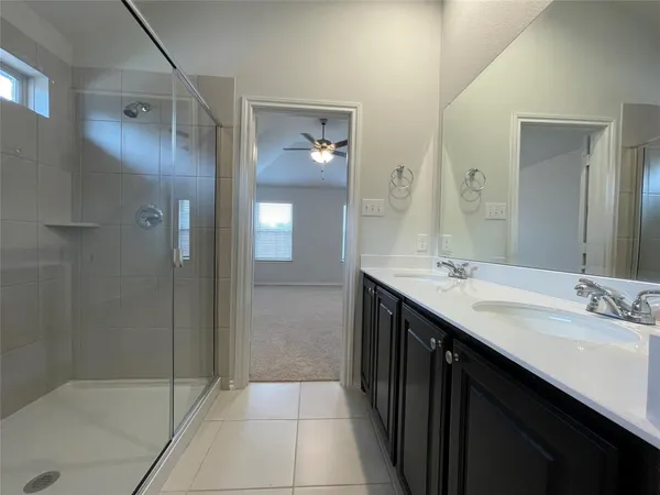 a bathroom with a double vanity sink mirror and shower