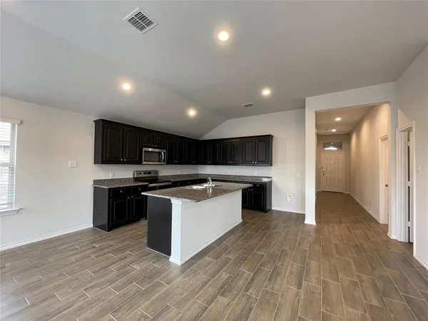 a large kitchen with stainless steel appliances granite countertop a stove and a sink