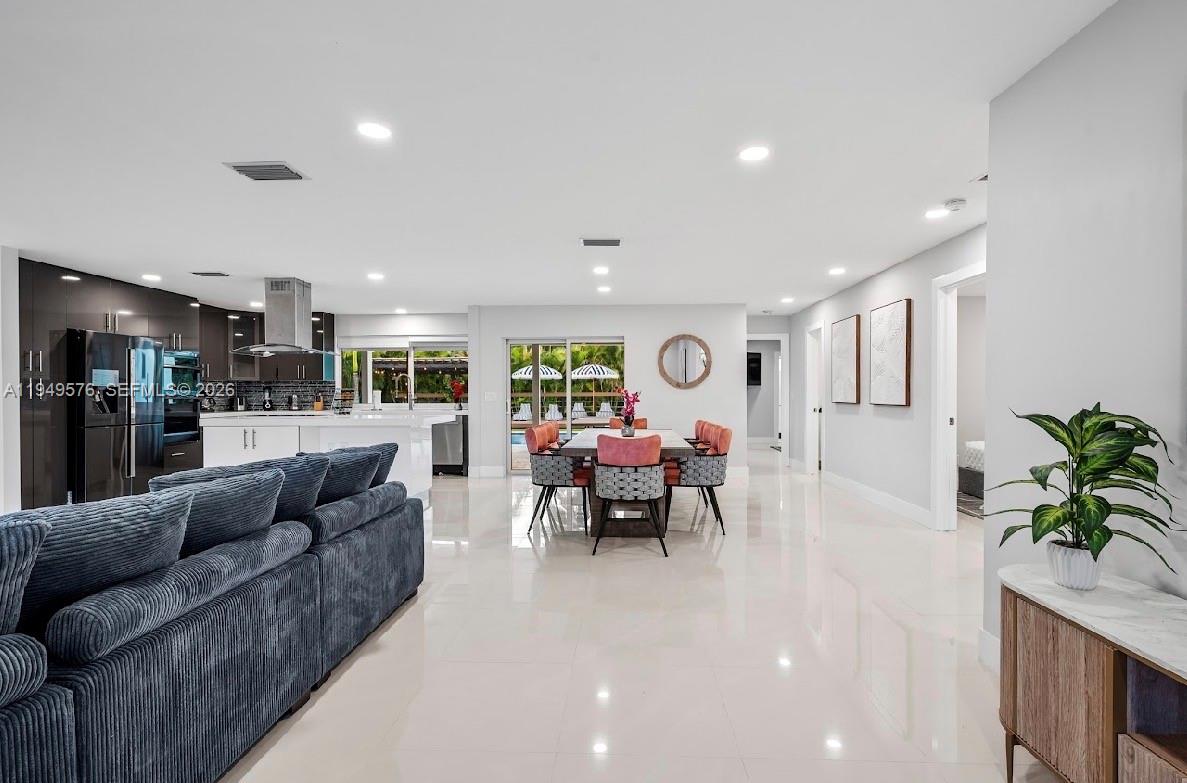 5111 Adams Street Hollywood, FL 33021 - Photo 24 of 66 a living room with furniture and a dining table with kitchen view
