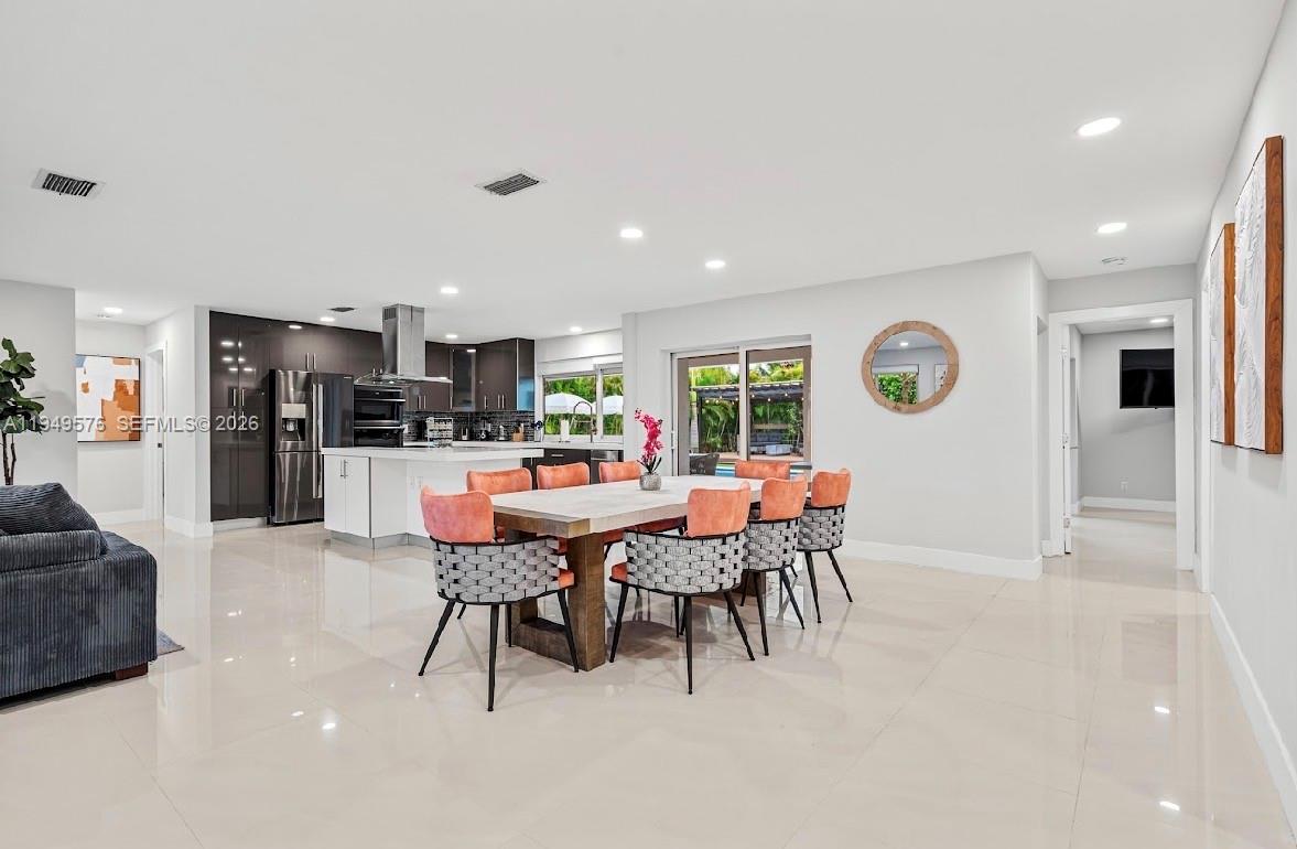 5111 Adams Street Hollywood, FL 33021 - Photo 30 of 66 a dining area with stainless steel appliances kitchen island granite countertop a dining table chairs and a refrigerator