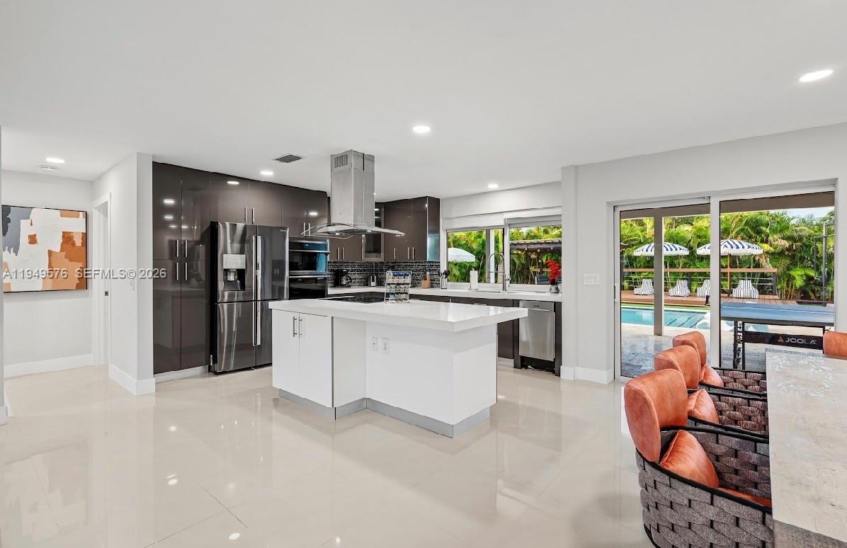 5111 Adams Street Hollywood, FL 33021 - Photo 32 of 66 a kitchen with stainless steel appliances kitchen island granite countertop a refrigerator and cabinets