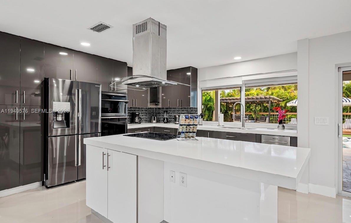 5111 Adams Street Hollywood, FL 33021 - Photo 35 of 66 a kitchen with stainless steel appliances a sink a stove a refrigerator and cabinets