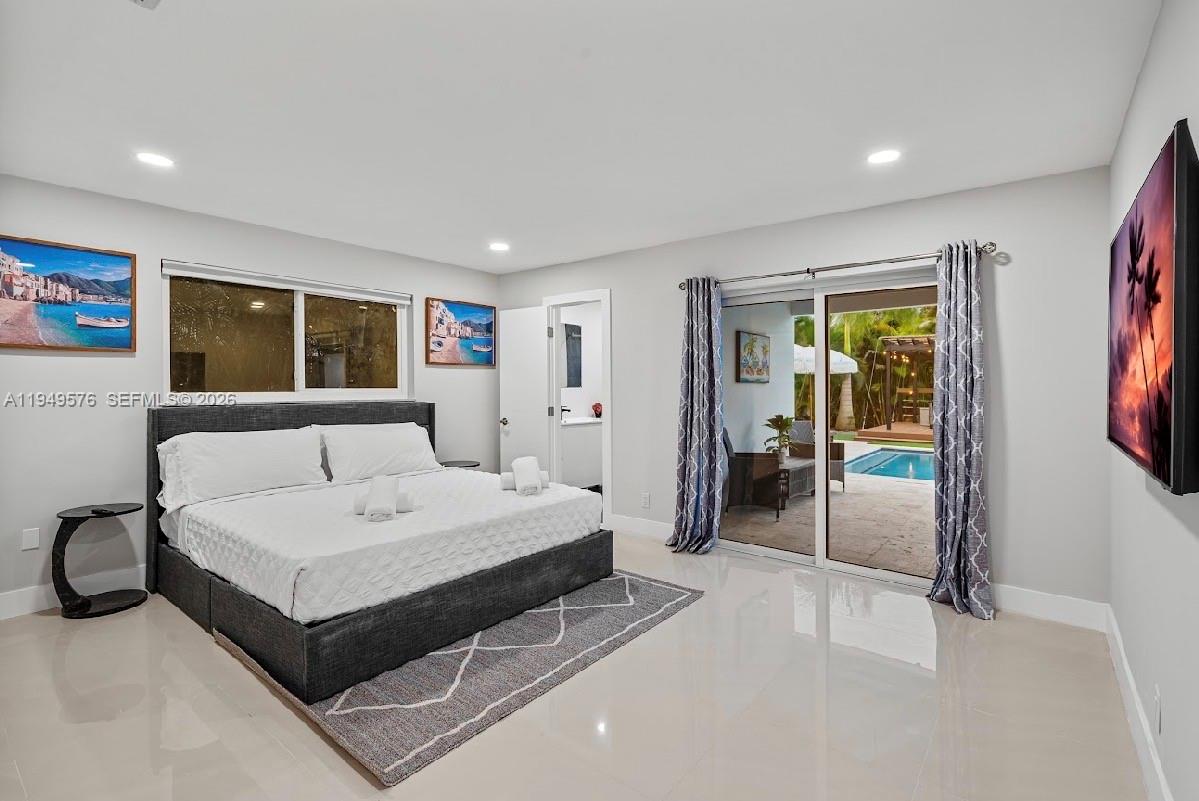 5111 Adams Street Hollywood, FL 33021 - Photo 36 of 66 a spacious bedroom with a bed and a large window