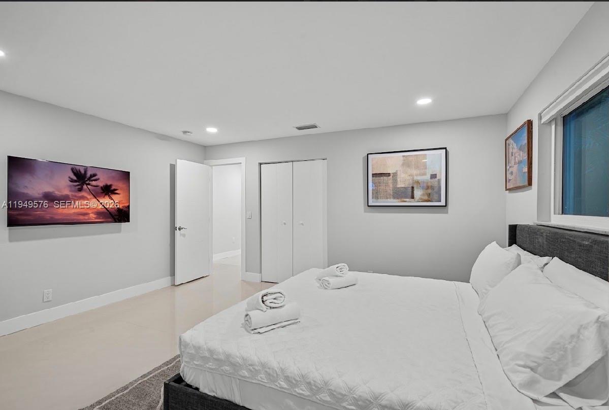 5111 Adams Street Hollywood, FL 33021 - Photo 37 of 66 a bedroom with a bed and a wall painting