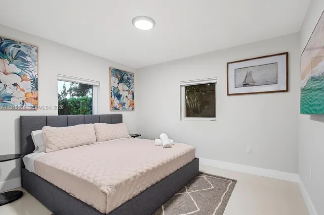 a bedroom with furniture and a large window