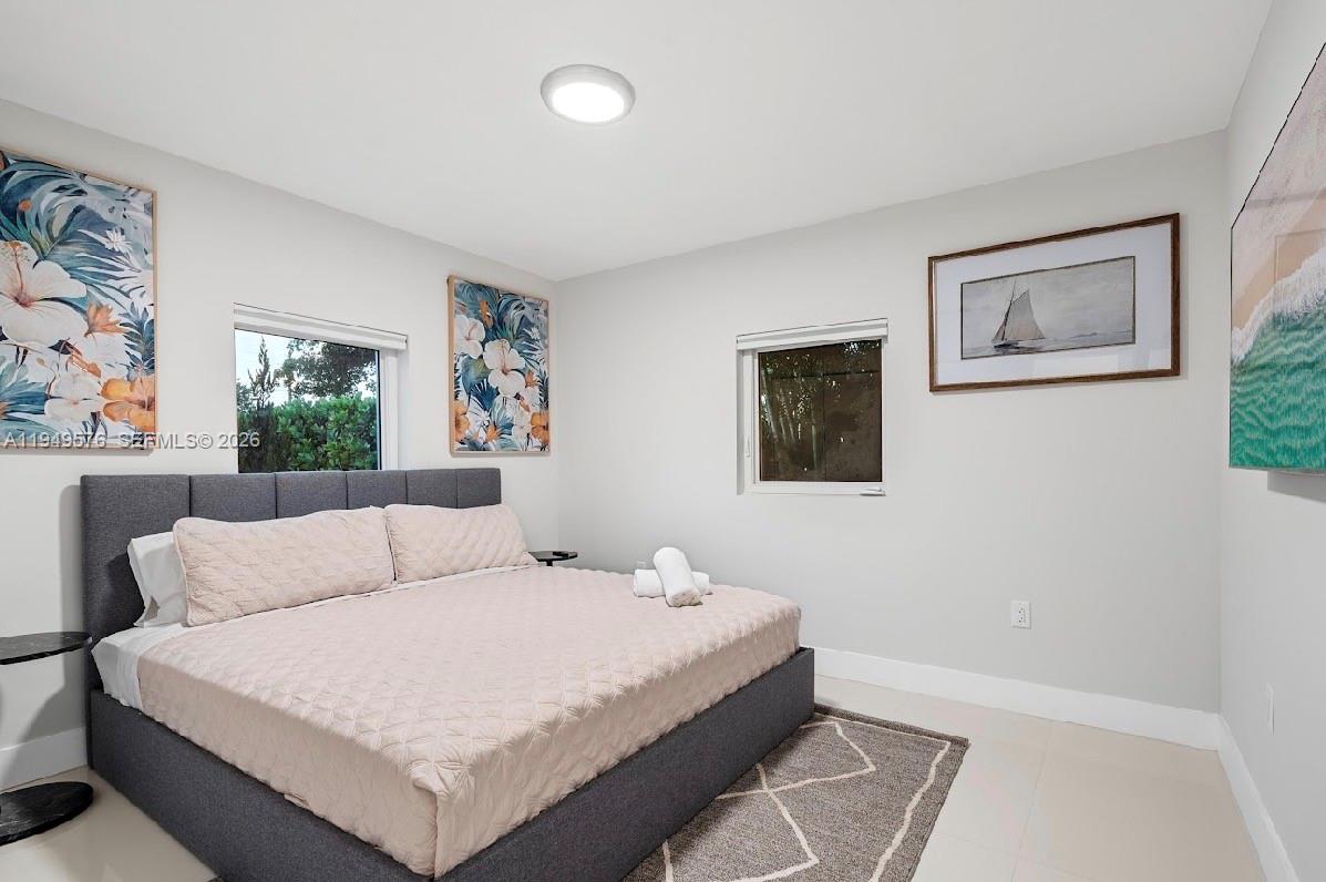 5111 Adams Street Hollywood, FL 33021 - Photo 38 of 66 a bedroom with a large bed and a couch