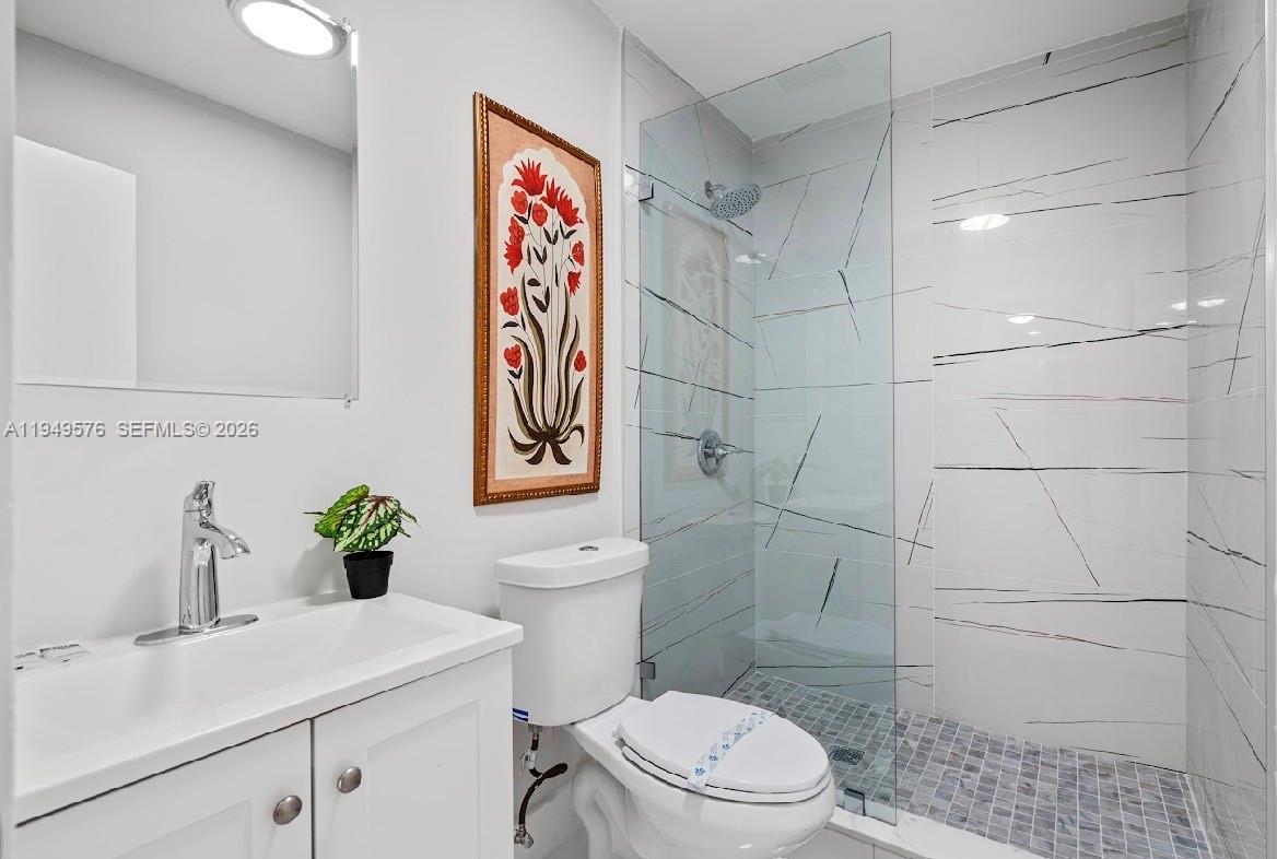 5111 Adams Street Hollywood, FL 33021 - Photo 41 of 66 a bathroom with a toilet sink and mirror