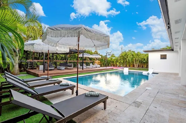 a view of a patio with couches chairs and wooden floor