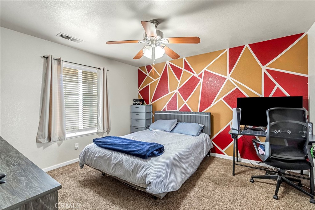 19729 Brightwood Road Madera, CA 93638 - Photo 17 of 33 a bedroom with a bed and a chandelier