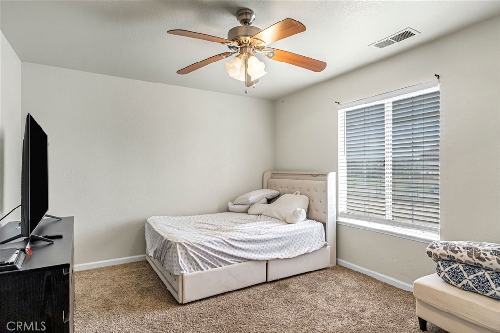 19729 Brightwood Road Madera, CA 93638 - Photo 19 of 33 a bedroom with a bed and a chandelier