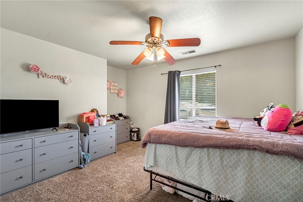 19729 Brightwood Road Madera, CA 93638 - Photo 21 of 33 a bedroom with a bed and flat screen tv