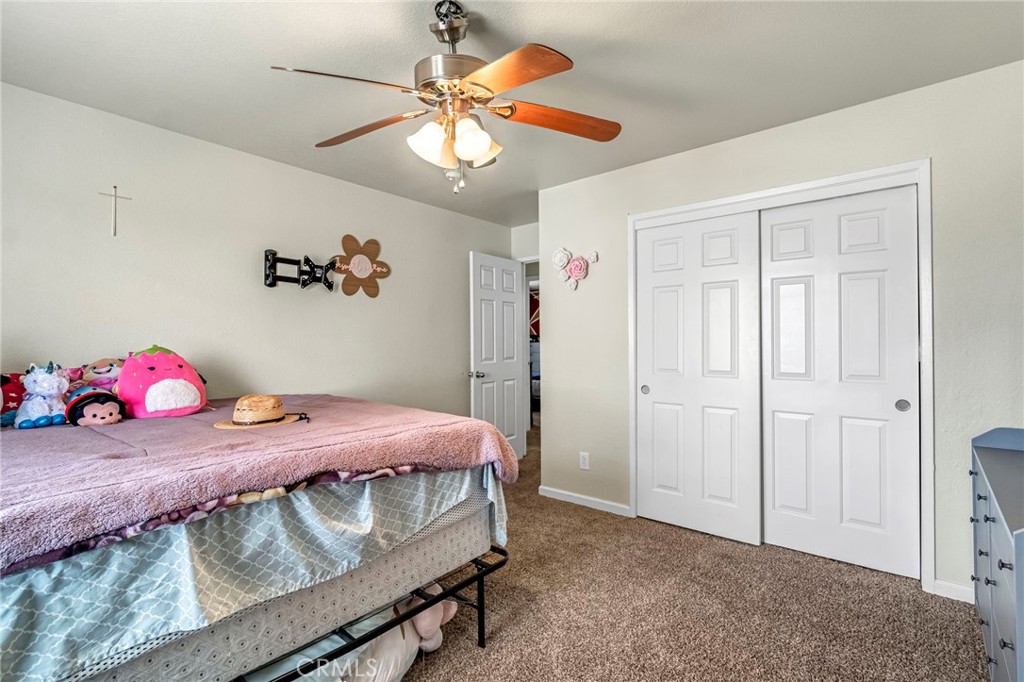 19729 Brightwood Road Madera, CA 93638 - Photo 22 of 33 a bedroom with a bed and a chandelier