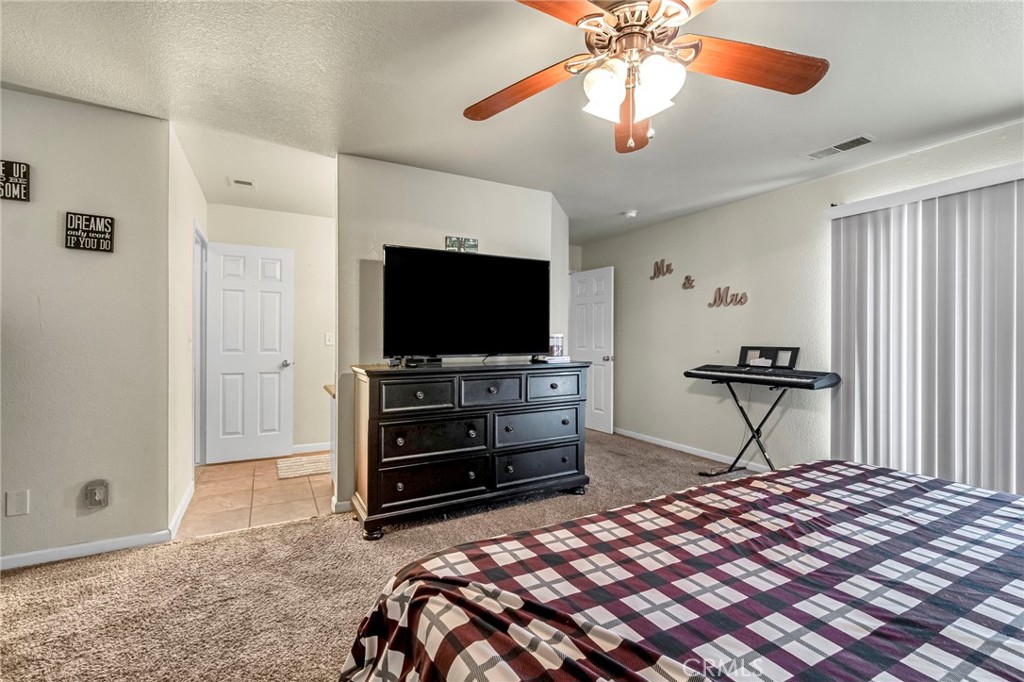 19729 Brightwood Road Madera, CA 93638 - Photo 24 of 33 a bedroom with a bed and a flat tv screen on dresser