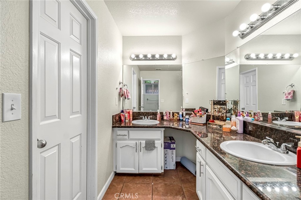 19729 Brightwood Road Madera, CA 93638 - Photo 25 of 33 a bathroom with a double vanity sink and a mirror