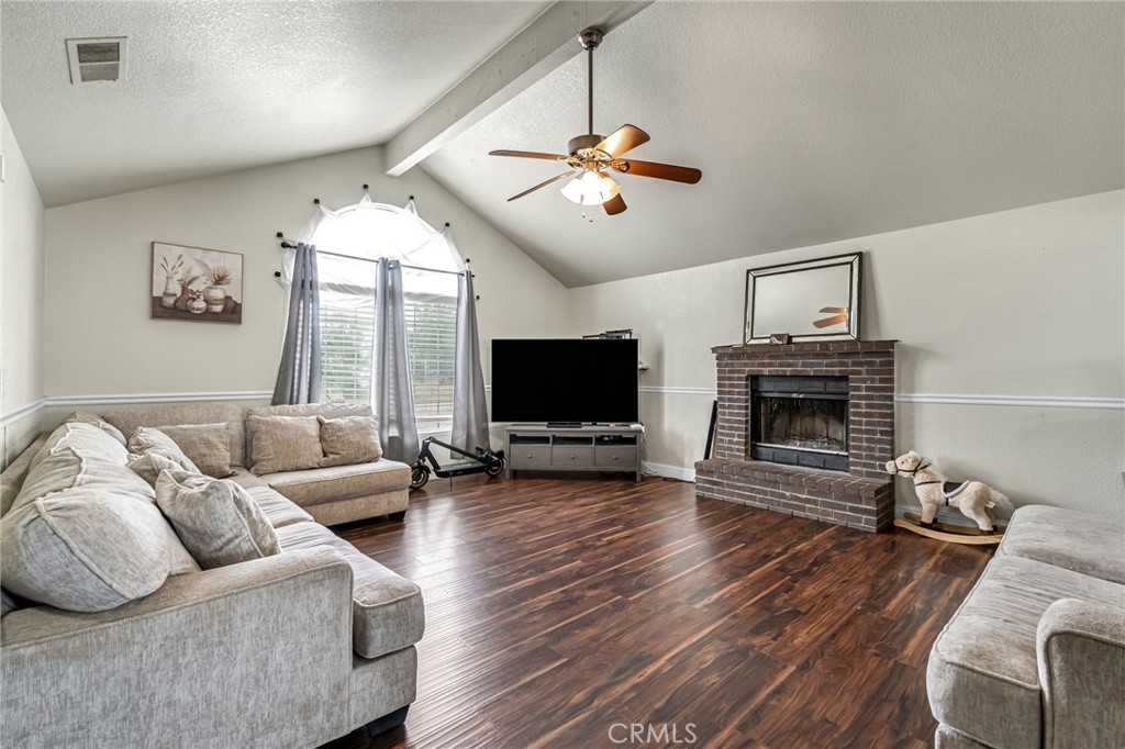 19729 Brightwood Road Madera, CA 93638 - Photo 7 of 33 a living room with furniture a flat screen tv and a fireplace