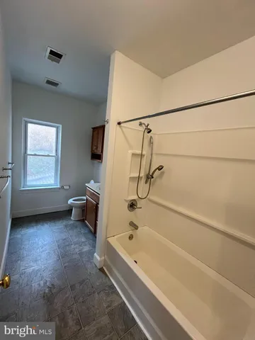 a bathroom with a tub and a window
