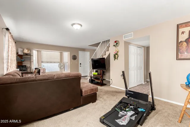a living room with furniture a window and a flat screen tv