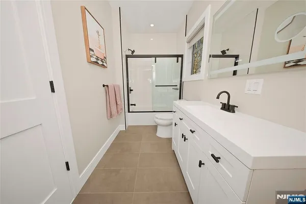 a bathroom with a double vanity sink a mirror and shower