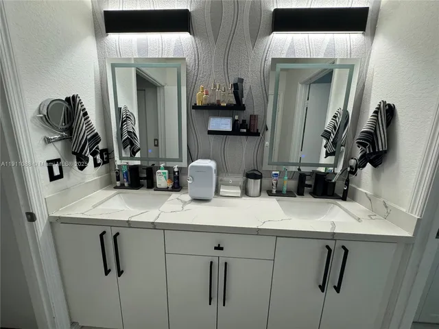 a bathroom with a sink vanity and mirror