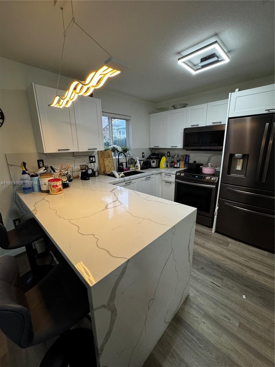 167 Southwest 6th Lane Florida City, FL 33034 - Photo 2 of 19 a kitchen with kitchen island a sink appliances and cabinets