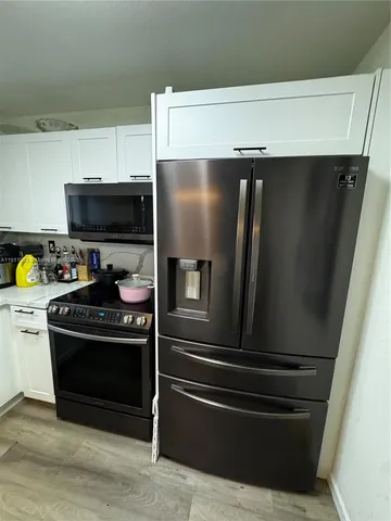a kitchen with stainless steel appliances and wooden cabinets
