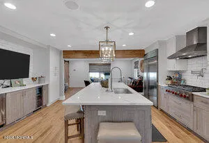 a kitchen with sink a refrigerator and chairs