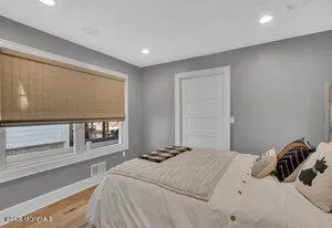 a bedroom with a bed and a large window