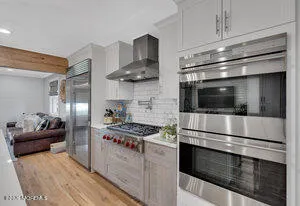 a kitchen with stainless steel appliances kitchen island granite countertop a stove and a refrigerator
